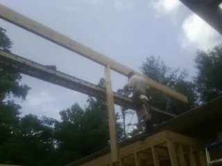 Carpenter setting a ridge beam over a new addition frame — Ice Dam Removal by Roofing Brothers in Weimar