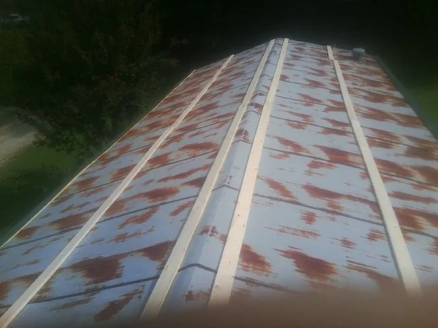 Rusted metal roof panels with new wood purlins before replacement — Storm Damage Roof Repair in Weimar by Roofing Brothers