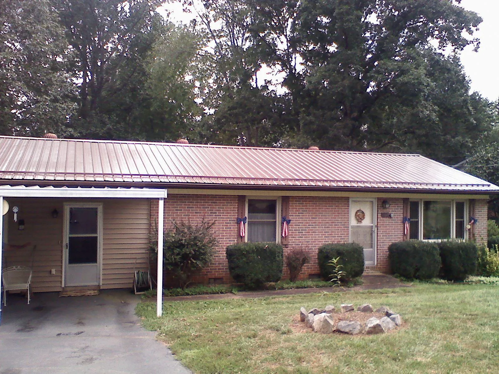 Bronze metal roof and carport on a brick ranch home — Roof Repair work by our crew in Weimar